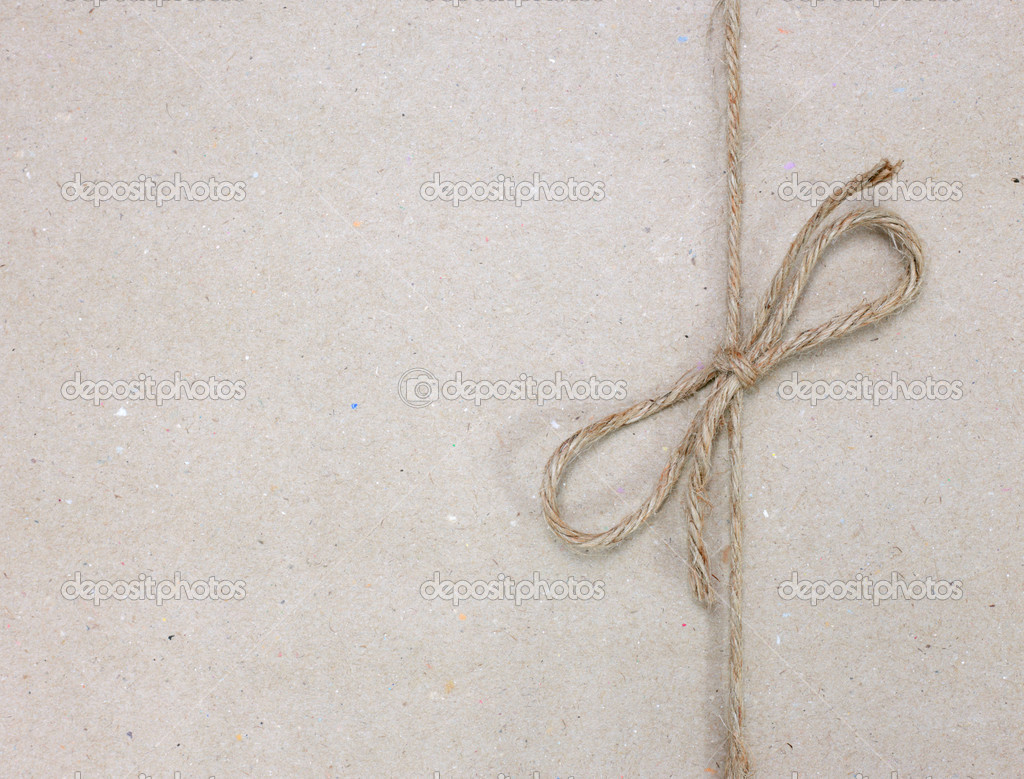 String tied in a bow on a brown recycled paper Stock Photo by